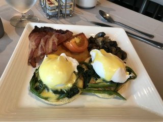 Egg Benedict mit Bacon und Pilzen. Ein typisches Frühstück im Bedienrestaurant an Bord der Ovation of the Seas